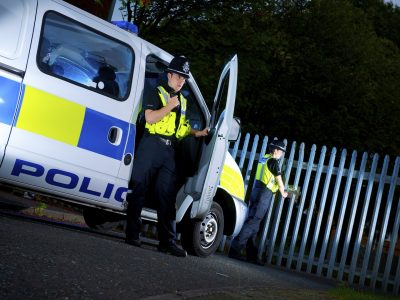 Police officers with van checking gates